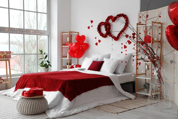 Interior of light bedroom decorated with hearts for Valentine\'s Day celebration