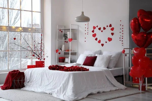 Interior of light bedroom decorated with hearts for Valentine\'s Day celebration