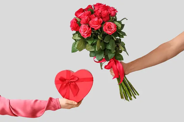 Женские Руки Подарочной Коробкой Букетом Красных Роз Сером Фоне Празднование — стоковое фото