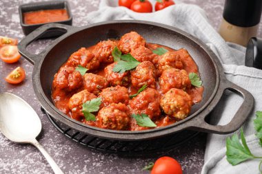 Domates soslu lezzetli köfte tavası ve gri arka planda maydanoz.