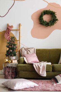 Masada Noel ağacı, parlayan ışıklar ve yeşil kanepe olan oturma odasının içinde.