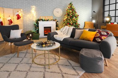 İçinde kanepe, koltuk, şömine, Noel ağacı ve parıldayan ışıklar olan karanlık bir oturma odası.