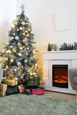 Noel ağacı, şömine ve hediye kutuları oturma odasının içinde.