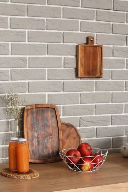 Elmalı ahşap tezgah, tabak rafı ve modern mutfakta meyve suyu şişeleri.