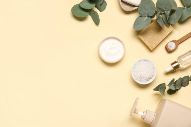 Renk arkaplan üzerinde farklı kozmetik ürünleri ve okaliptüs dalları içeren kompozisyon
