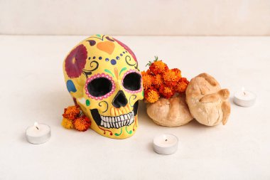 Mumlarla, çiçeklerle ve beyaz arka planda boyanmış kafatasıyla ölülerin ekmeği. Meksika Ölüler Günü 'nün Kutlaması (El Dia de Muertos)