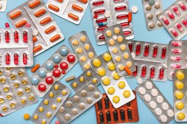 Mavi arka planda farklı haplar içeren kabarcık paketleri