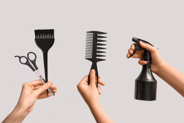 Beyaz arka planda saç malzemesi olan kadın eller..