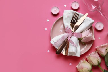 Sevgililer Günü için masa ayarı pembe arka planda güller ve mumlarla