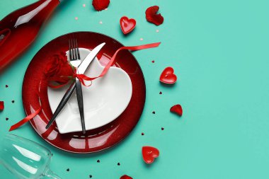 Sevgililer Günü için yeşil arka planda gül ve mumlarla birlikte masa ayarı