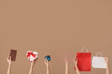 Cüzdanı, hediyesi, kredi kartları ve kahverengi çantalı kadınlar. Sevgililer Günü kutlaması