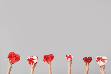 Hafif arka planda kalp şeklinde hediye kutuları olan kadınlar. Sevgililer Günü kutlaması