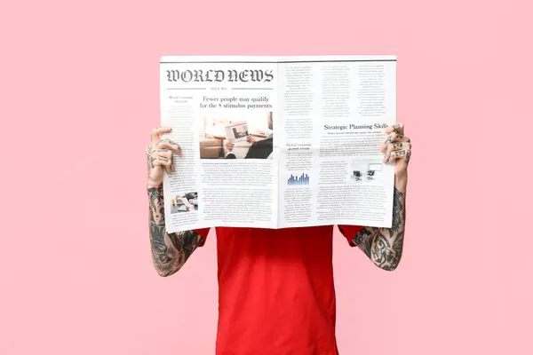 Man with newspaper on pink background
