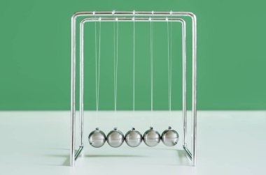 Yeşil duvarın yanındaki masada Newton 'un Beşiği