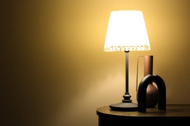 Parlayan lamba, vazo ve dekorasyon Karanlık odada ahşap masada