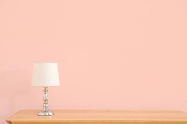 Lamba, pembe duvarın yanındaki ahşap masada.