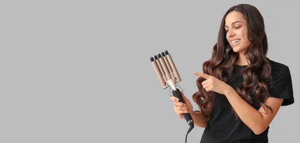 Beautiful Young Woman Curling Iron Grey Background Space Text — Stockfoto