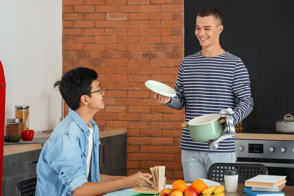 Male students having dinner in dorm kitchen