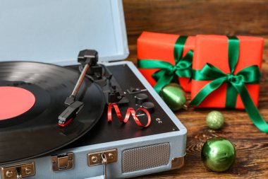 Vinil plak çalar ve Noel hediyeleri ahşap arka planda