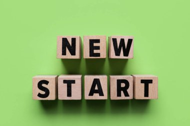 Metni olan küpler yeşil arkaplan üzerinde YENİ Başlat