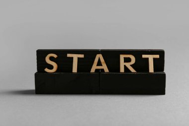 Gri arkaplanda Başlat sözcüğüyle siyah bloklar