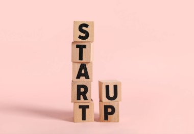 Pembe arka planda sözcük Startup küpler