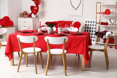 Sevgililer Günü 'nde evde kırmızı güller ve mumlarla süslenmiş şenlik masası.