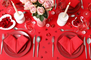 Sevgililer Günü kutlaması için yemek masası, mumlar ve pembe güller.