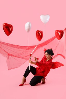 Eros 'un kanatlarına ve pembe arka plana sahip genç Afro-Amerikan kadın. Sevgililer Günü kutlaması