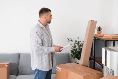 Depoda çalışan panolu bir erkek satıcı.