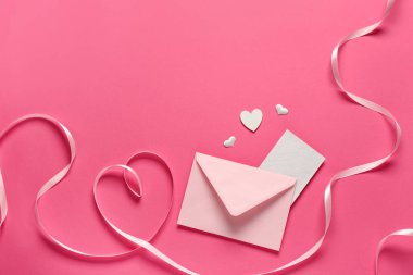 Zarflı kompozisyon, kart ve pembe arka planda dekor. Sevgililer Günü kutlaması