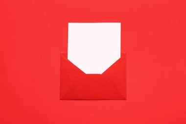 Kırmızı zemin üzerinde zarf ve kart olan kompozisyon. Sevgililer Günü kutlaması