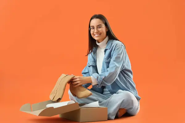 Female Seller Boots Box Orange Background — Stock Photo, Image