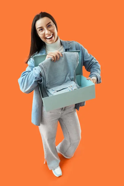 Female Seller Jeans Box Orange Background — Stock Photo, Image