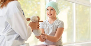 Doctor and little girl with toy in clinic