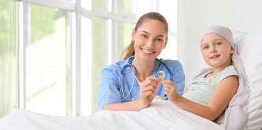 Nurse and little girl with golden ribbon in clinic