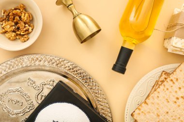 Composition with bottle of wine, cup, Passover Seder plate, flatbread matza and walnuts on color background, closeup