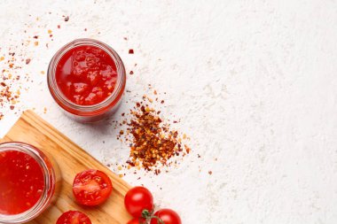 Açık arkaplanda lezzetli domates soslu kavanozlar.