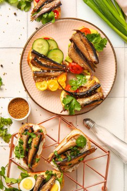 Beyaz fayanslı tütsülenmiş lahanalı lezzetli sandviçlerden oluşan tabak ve ızgara.