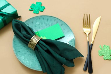 Beautiful table setting for St. Patrick's Day celebration on beige background