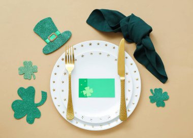Beautiful table setting for St. Patrick's Day celebration on beige background