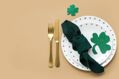 Beautiful table setting for St. Patrick's Day celebration on beige background