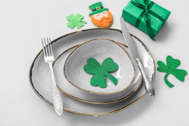 Beautiful table setting for St. Patrick's Day celebration on blue background