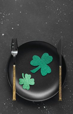 Beautiful table setting for St. Patrick's Day celebration on dark background