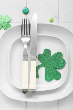 Beautiful table setting for St. Patrick's Day celebration on white tile background