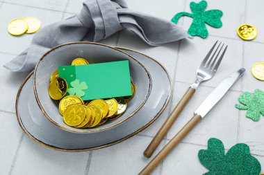 Beautiful table setting for St. Patrick's Day celebration on white tile background