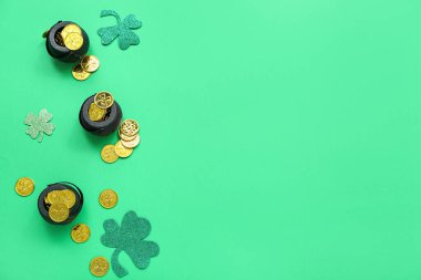 Pots with coins and paper clovers on green background. St. Patrick's Day celebration