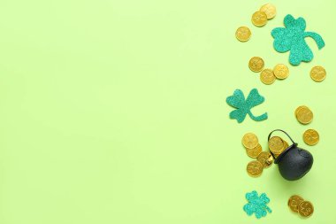 Pot with coins and paper clovers on light green background. St. Patrick's Day celebration