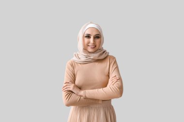 Young Muslim woman on light background. Islamic New Year celebration