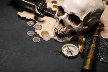 Kılıçlı, dürbünlü, pusulalı ve siyah arkaplanlı insan kafatası.